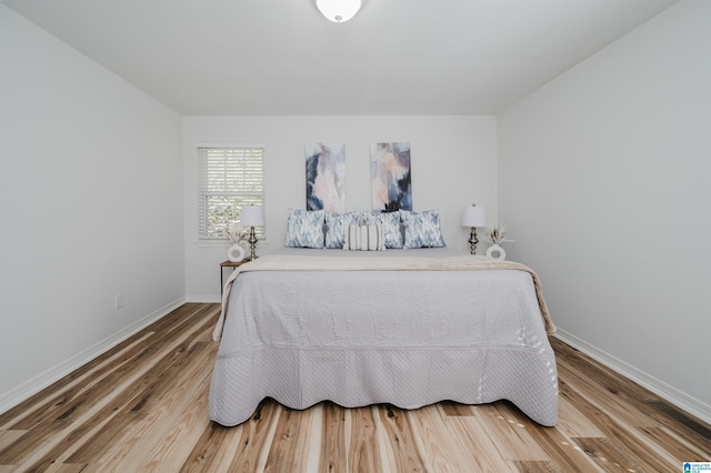 bedroom featuring wood finished floors and baseboards