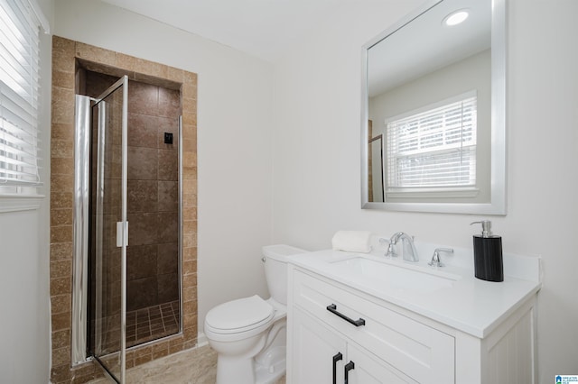 bathroom with toilet, a stall shower, and vanity