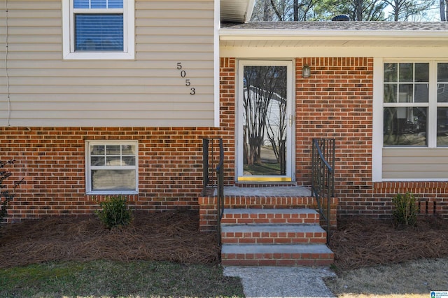 property entrance featuring brick siding