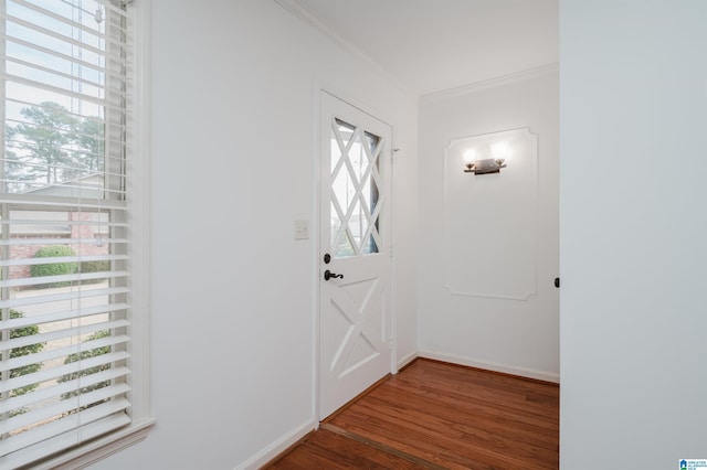 entrance foyer featuring ornamental molding, wood finished floors, and baseboards