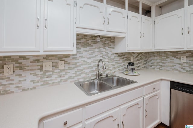 kitchen with stainless steel dishwasher, a sink, and white cabinetry