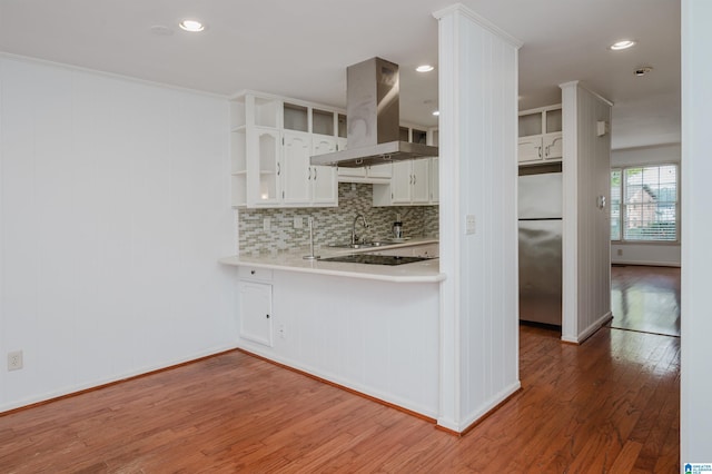 kitchen with stainless steel refrigerator, island exhaust hood, light countertops, white cabinetry, and open shelves