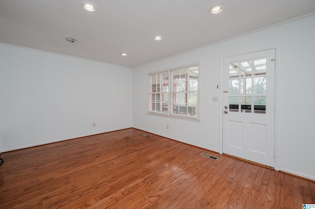 spare room with recessed lighting, visible vents, wood finished floors, and ornamental molding