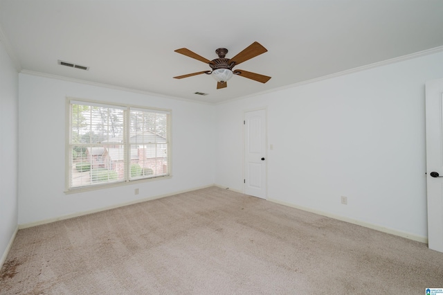 empty room featuring ornamental molding, a ceiling fan, visible vents, and light colored carpet