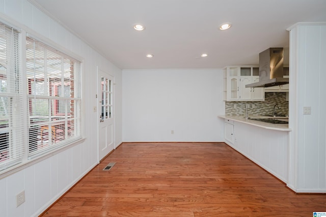 unfurnished dining area with light wood-type flooring, visible vents, crown molding, and recessed lighting