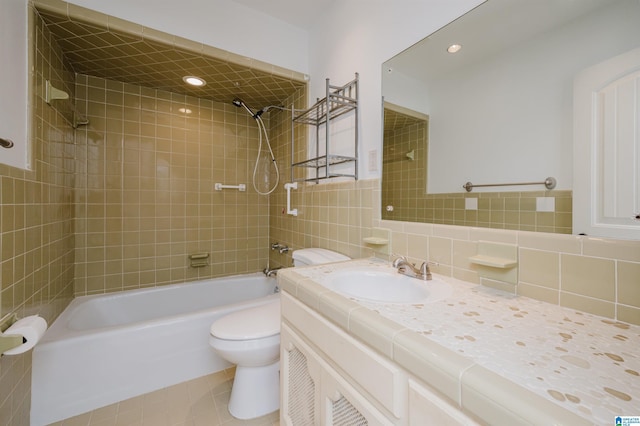 full bathroom featuring toilet, shower / bathtub combination, tile patterned flooring, vanity, and tile walls