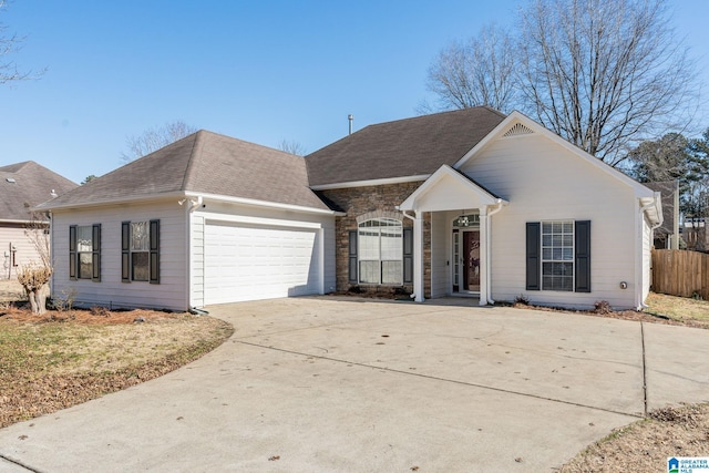 view of front of house featuring a garage, stone siding, driveway, and a shingled roof