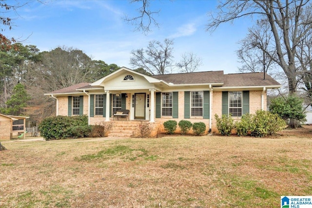 view of front of house featuring a porch, a front yard, and brick siding