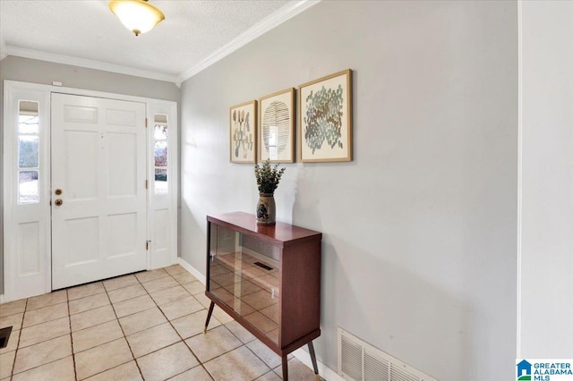 entryway with light tile patterned floors, baseboards, visible vents, a textured ceiling, and crown molding