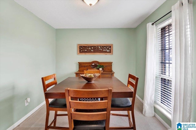 carpeted dining space with baseboards