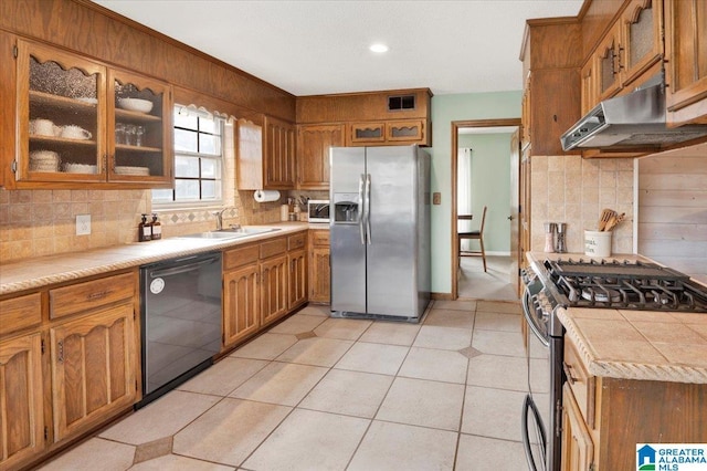 kitchen with appliances with stainless steel finishes, brown cabinets, visible vents, and under cabinet range hood