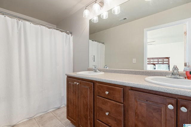 ensuite bathroom featuring tile patterned flooring, visible vents, ensuite bath, and a sink