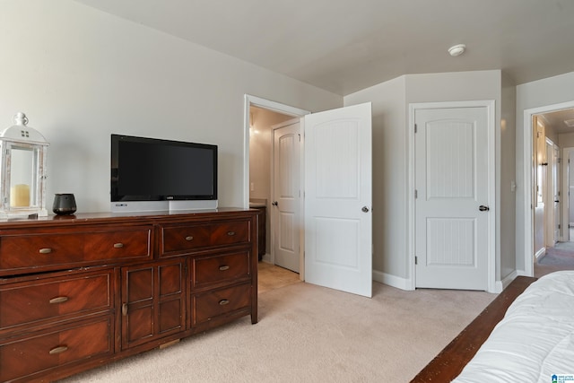 bedroom with baseboards and light carpet