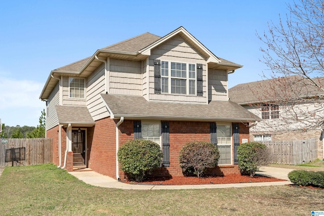 traditional home featuring brick siding, a shingled roof, a front yard, and fence