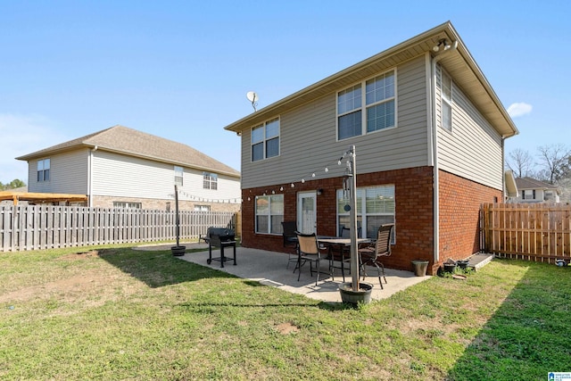 back of property with a yard, a fenced backyard, and brick siding