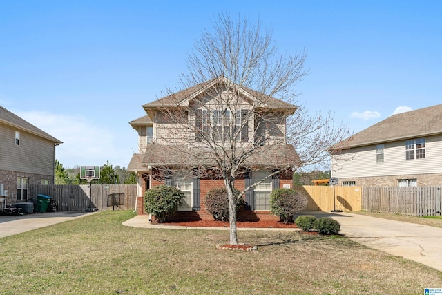 traditional-style home featuring a front lawn, fence, brick siding, and driveway