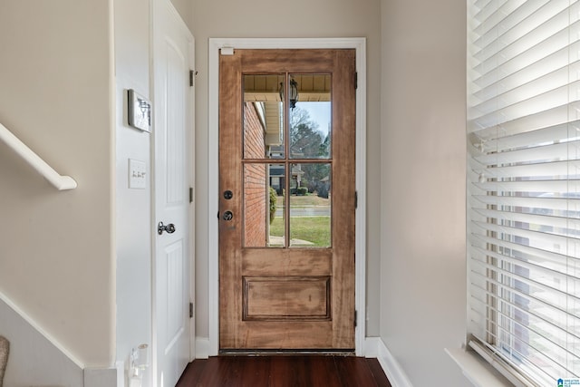 entryway with dark wood finished floors and baseboards