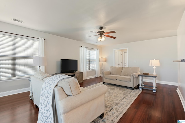 living room featuring visible vents, baseboards, wood finished floors, and a ceiling fan