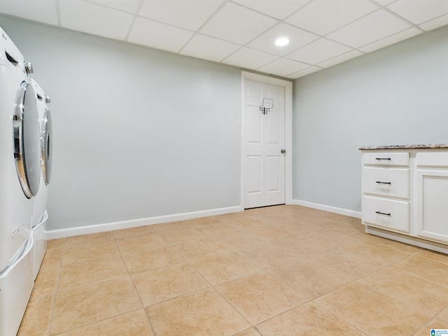 laundry area with light tile patterned floors, baseboards, separate washer and dryer, and cabinet space