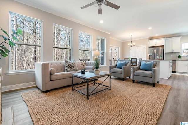 living room with recessed lighting, baseboards, crown molding, and wood finished floors