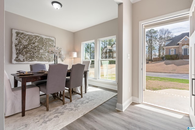 dining space featuring baseboards and wood finished floors