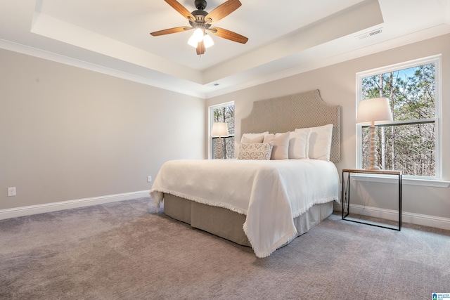 bedroom featuring carpet, baseboards, visible vents, and a raised ceiling