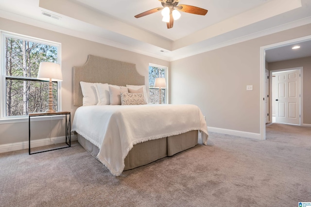 carpeted bedroom with ceiling fan, visible vents, baseboards, and a raised ceiling