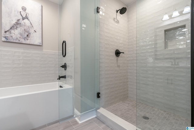 bathroom featuring a stall shower and a bathing tub