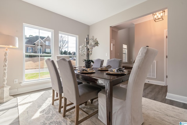 dining area featuring a wealth of natural light, visible vents, baseboards, and wood finished floors