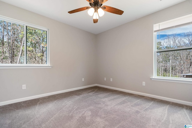 carpeted empty room featuring ceiling fan and baseboards