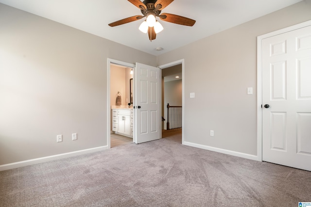 unfurnished bedroom with ensuite bath, light colored carpet, and baseboards