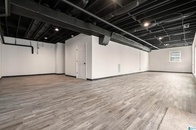 below grade area featuring baseboards and wood finished floors