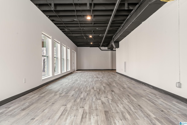 below grade area with baseboards and wood finished floors