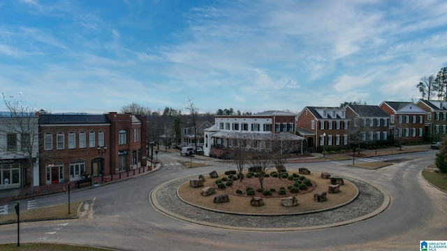 view of road with sidewalks, a residential view, street lights, and curbs