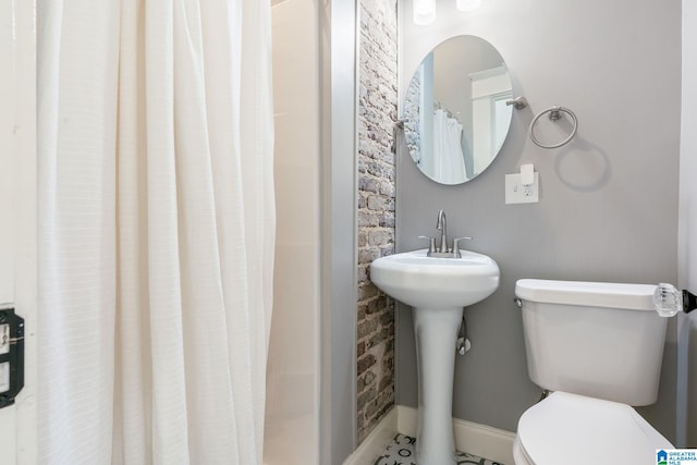 full bath featuring baseboards, a sink, a shower stall, and toilet