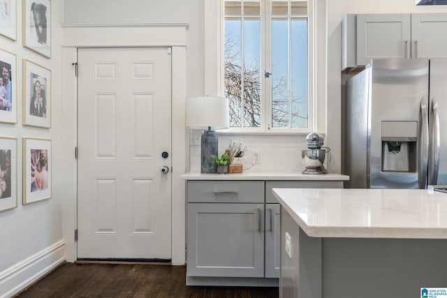 bar with stainless steel fridge, baseboards, dark wood-style flooring, and backsplash