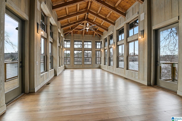 unfurnished sunroom featuring lofted ceiling, wood ceiling, and visible vents