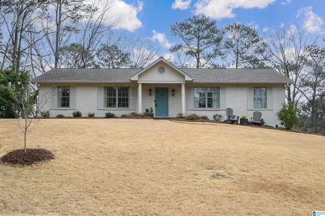 ranch-style house with brick siding, a shingled roof, and a front yard