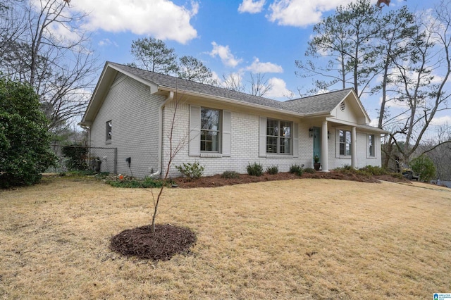 single story home with brick siding and a front yard