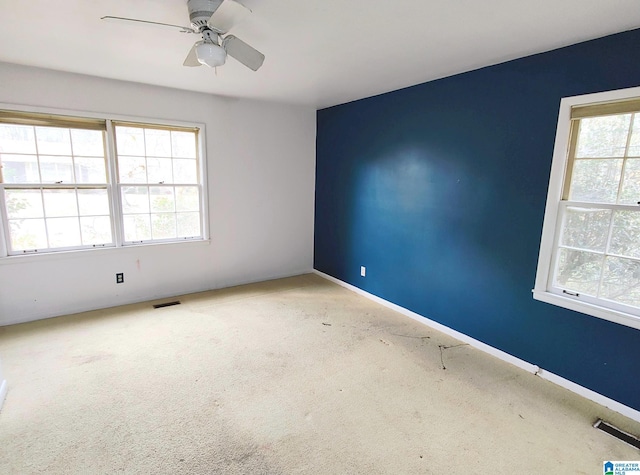 carpeted empty room with visible vents and a wealth of natural light