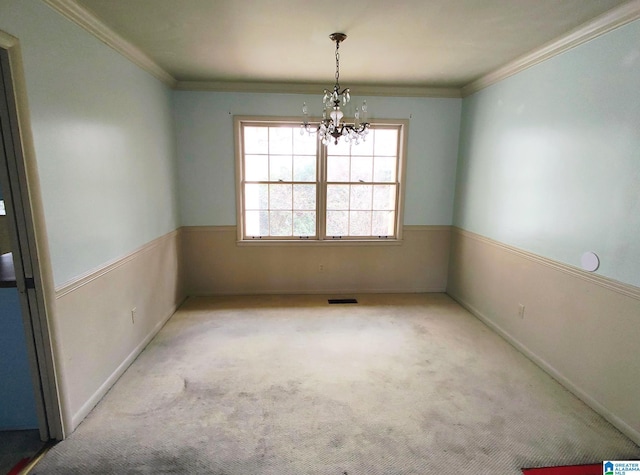 spare room with visible vents, ornamental molding, a notable chandelier, and light colored carpet