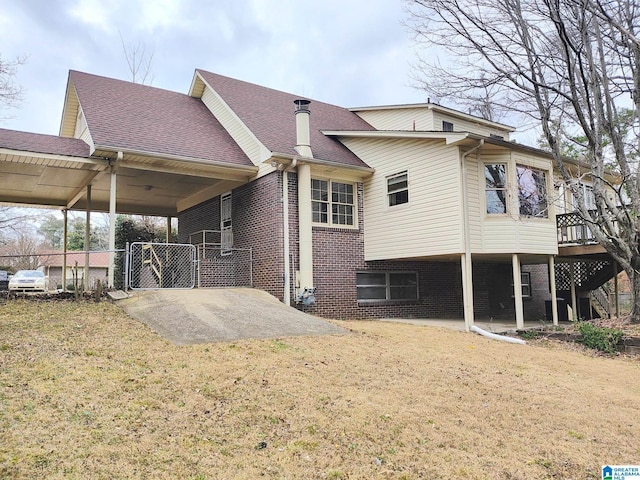 back of property with brick siding, fence, a lawn, and roof with shingles