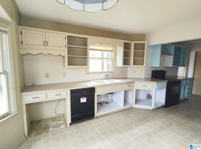 kitchen featuring open shelves, a sink, light countertops, black appliances, and built in desk