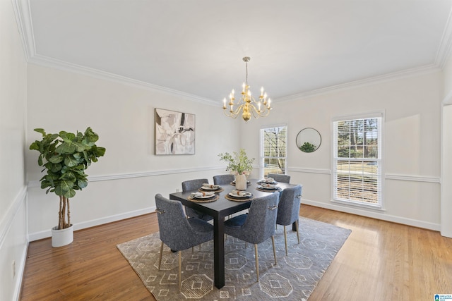 dining space featuring a notable chandelier, baseboards, ornamental molding, and wood finished floors