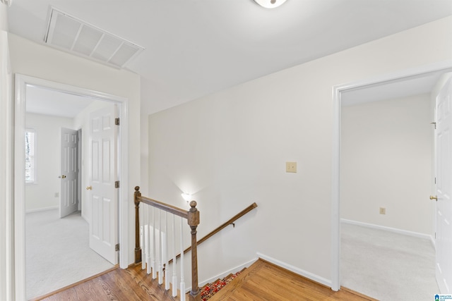 stairs featuring visible vents, baseboards, and wood finished floors