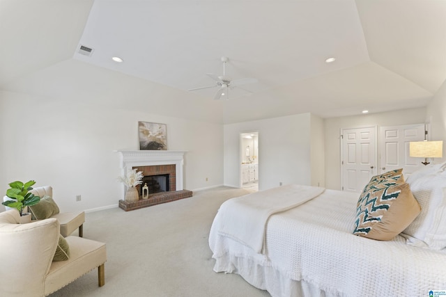 carpeted bedroom with recessed lighting, a fireplace, visible vents, vaulted ceiling, and a tray ceiling