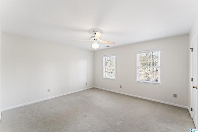 unfurnished room featuring light carpet, a ceiling fan, visible vents, and baseboards