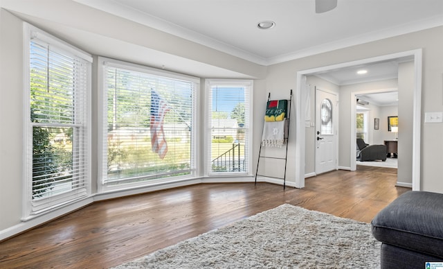 interior space with plenty of natural light, crown molding, baseboards, and wood finished floors