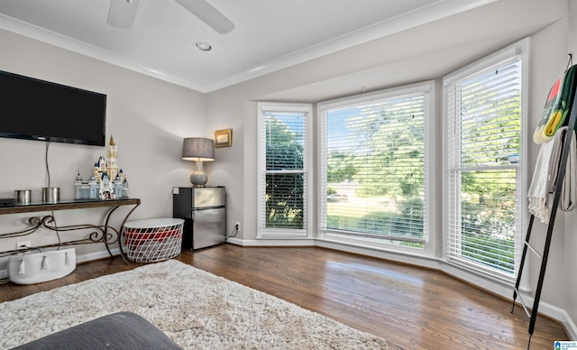 sitting room featuring a healthy amount of sunlight, crown molding, baseboards, and wood finished floors