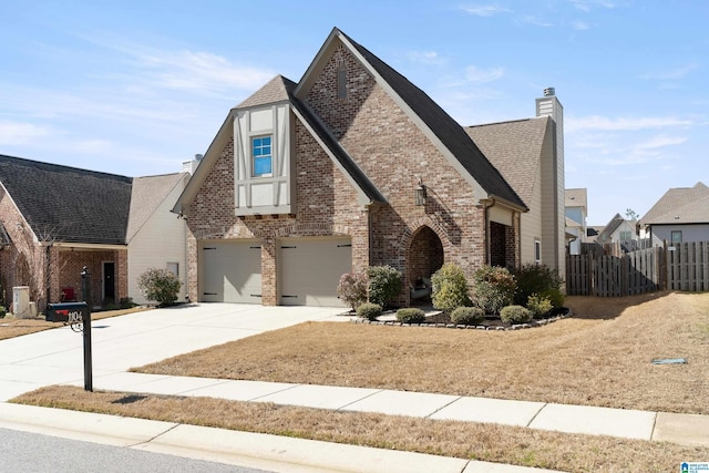 view of front facade with a garage, concrete driveway, a chimney, fence, and brick siding